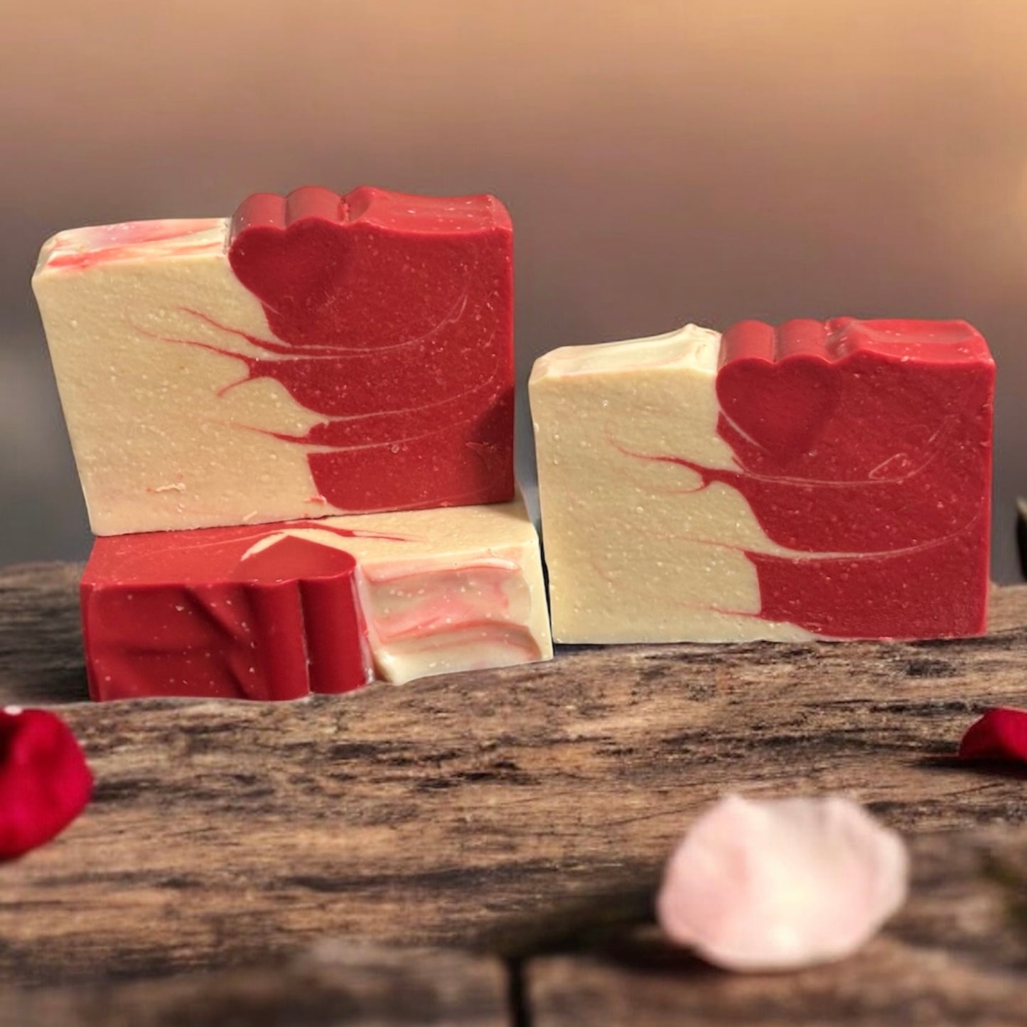 Red and white marbled soap bars on a wooden surface with a blurred background with a red heart embed