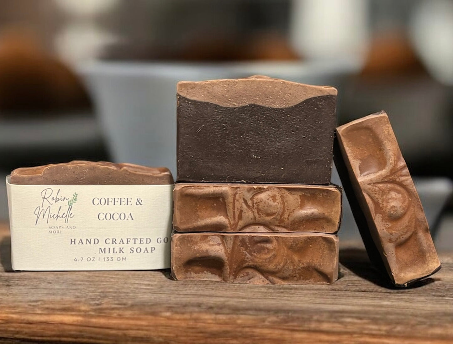 Handcrafted coffee and cocoa soap bars on a wooden surface with a blurred background