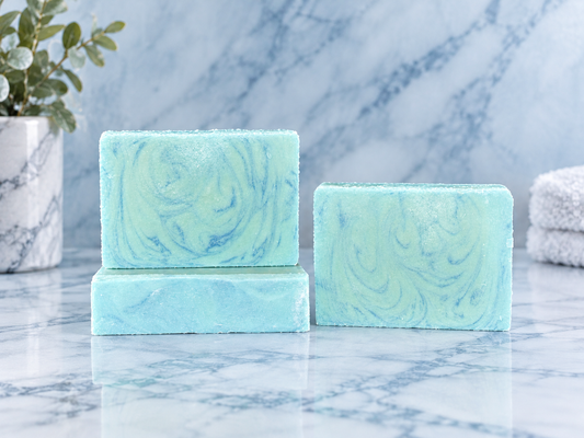 Three marbled blue soaps on a marbled counter.