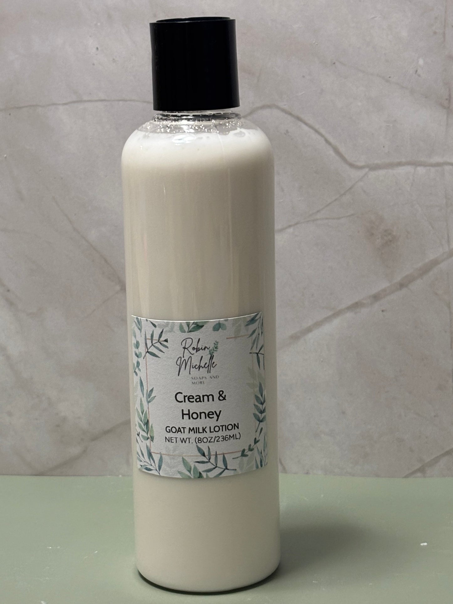 Bottle of Cream & Honey goat milk lotion on a marble surface