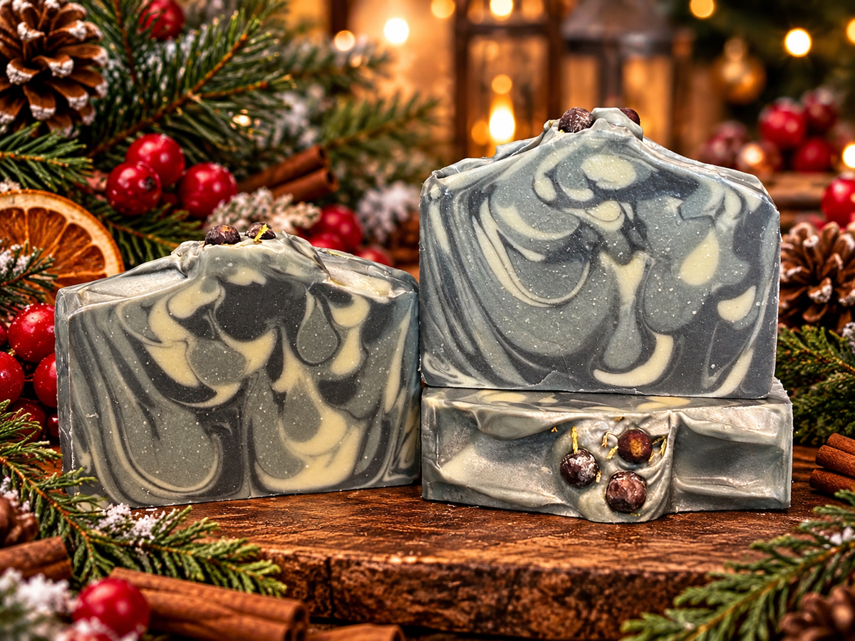 Three swirled soaps with 3 shades of green and topped with cedar and juniper berries on a Christmas background.