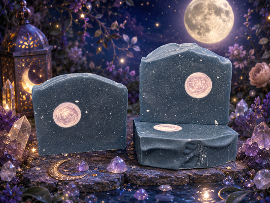 Three pieces of dark soap with star patterns on a mystical background with crystals and flowers.
